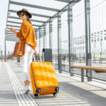 Young Female Traveler With A Luggage At The Transport Stop